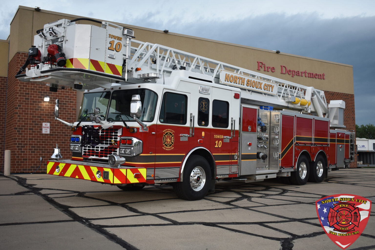 North Sioux City red and white fire department ladder truck parked in front of a fire station.
