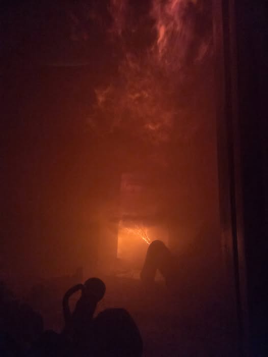 Dense orange smoke and flames filling a dark room.